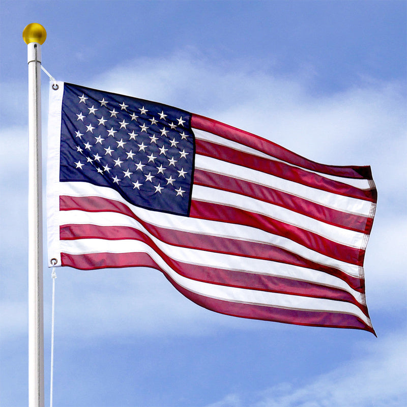 American flag waving against a blue sky with some clouds